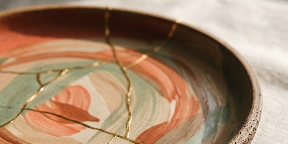 Assiette kintsugi réparée à l'or, corail et vert